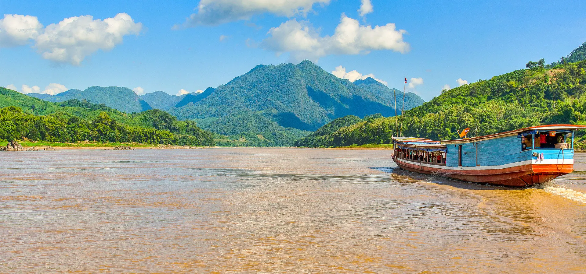 Traditional wooden boats on the Mekong River at a bustling floating market in Vietnam. 