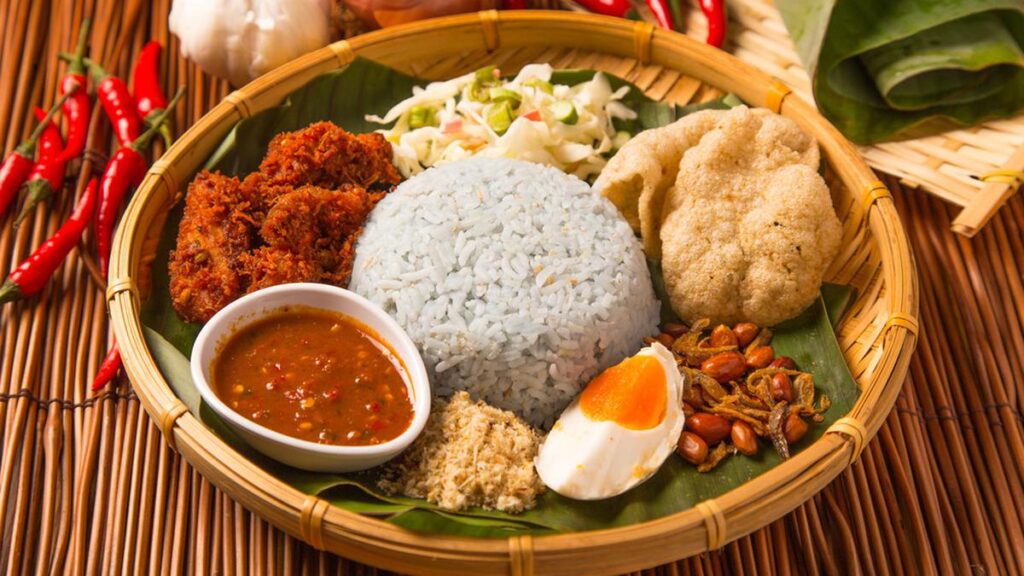 Nasi Ulam khas Nusantara, disajikan dengan taburan bawang goreng, daun kemangi, dan lauk pendamping yang menggugah selera