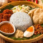 Nasi Ulam khas Nusantara, disajikan dengan taburan bawang goreng, daun kemangi, dan lauk pendamping yang menggugah selera