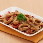 Hidangan sotong saus mentega yang gurih dan manis, disajikan dengan saus kental dan hiasan daun bawang